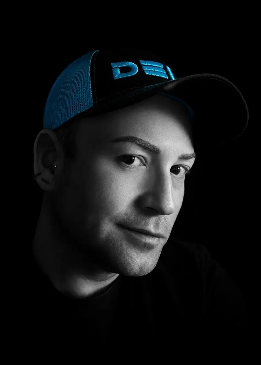 Steve Dela portrait — signature Dela cap